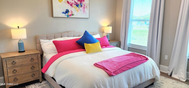 bedroom with baseboards and wood finished floors