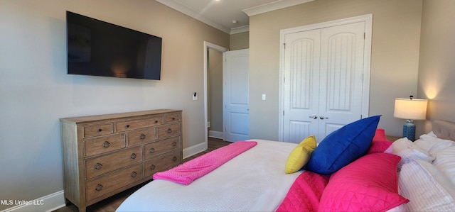 bedroom featuring baseboards, a closet, and crown molding