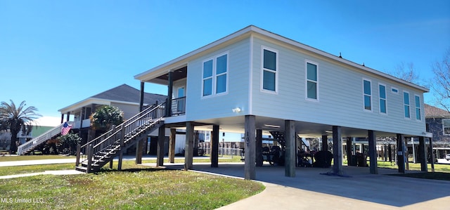 exterior space featuring stairs, a carport, and concrete driveway