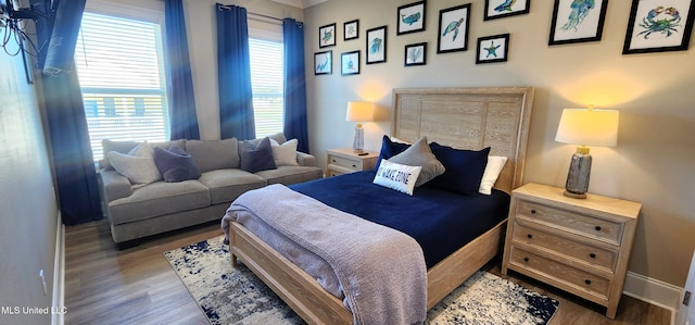 bedroom with baseboards and wood finished floors