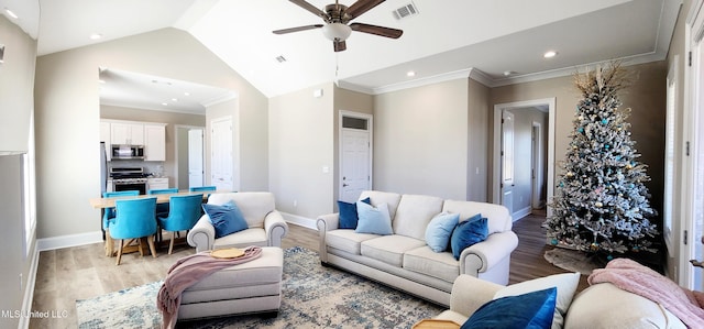 living area with lofted ceiling, ornamental molding, wood finished floors, and visible vents