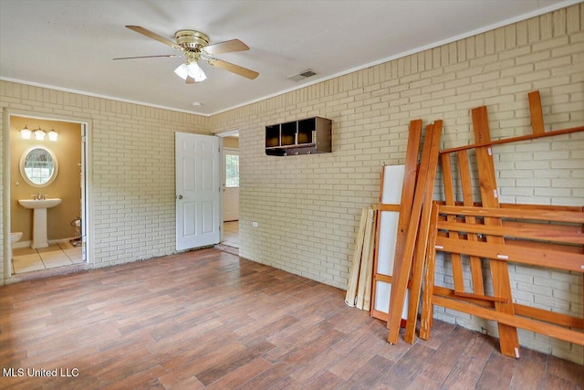 428 Simpson Cir, Mendenhall, MS 39114 - unfurnished bedroom with brick wall, a sink, wood finished floors, ornamental molding, and connected bathroom