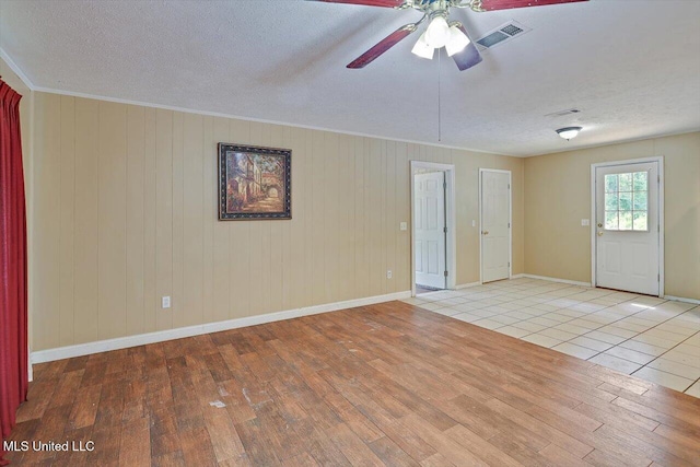 428 Simpson Cir, Mendenhall, MS 39114 - unfurnished room with wood finished floors, ceiling fan, a textured ceiling, baseboards, and wood walls