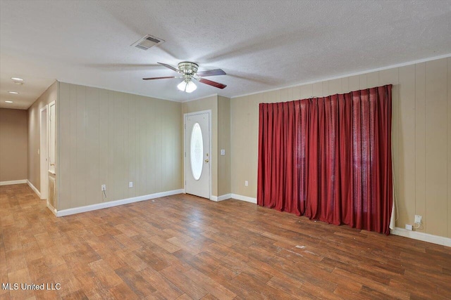 428 Simpson Cir, Mendenhall, MS 39114 - empty room featuring wood finished floors, ceiling fan, baseboards, a textured ceiling, and wooden walls