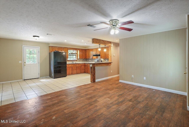 428 Simpson Cir, Mendenhall, MS 39114 - kitchen featuring freestanding refrigerator, light wood-style flooring, brown cabinets, baseboards, and a ceiling fan