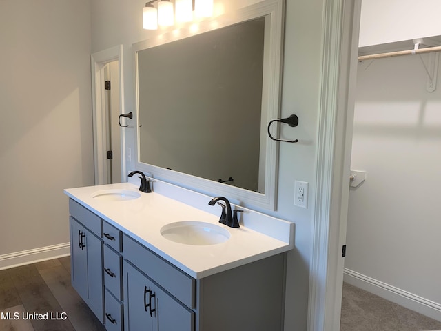 10229 Patrick Dr, Gulfport, MS 39503 - full bathroom featuring baseboards, double vanity, a sink, and a walk in closet
