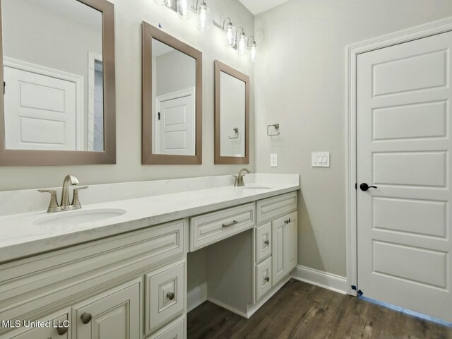 10507 Glade Cv, Gulfport, MS 39503 - full bathroom featuring double vanity, a sink, wood finished floors, and baseboards