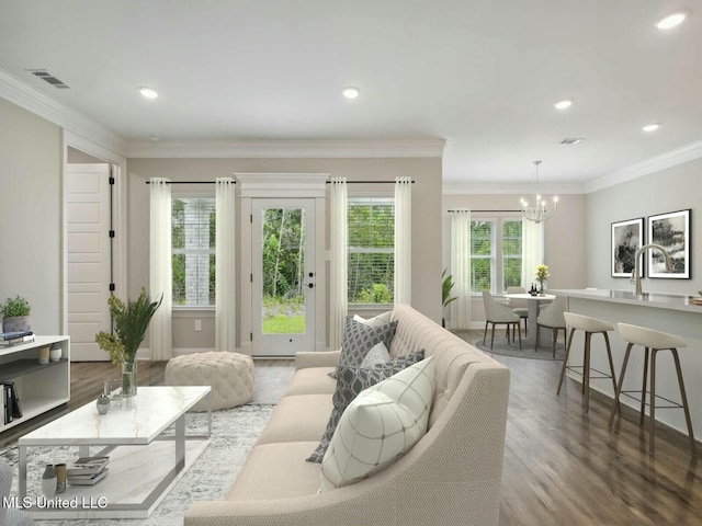10507 Glade Cv, Gulfport, MS 39503 - living area with visible vents, an inviting chandelier, recessed lighting, ornamental molding, and wood finished floors