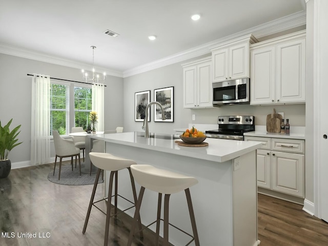 10507 Glade Cv, Gulfport, MS 39503 - kitchen with a sink, stainless steel appliances, a center island with sink, dark wood-type flooring, and light countertops