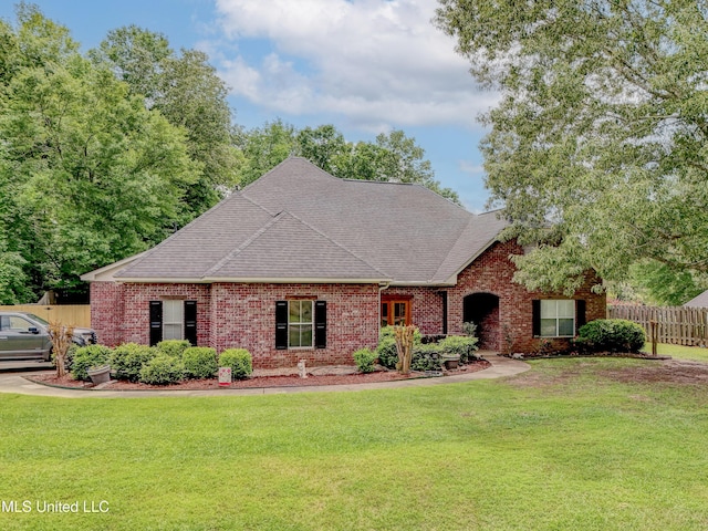 102 Grand Bear Cir, Vicksburg, MS 39183 - view of front of home featuring roof with shingles, fence, brick siding, and a front yard
