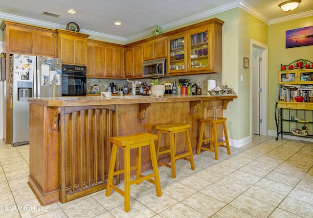 102 Grand Bear Cir, Vicksburg, MS 39183 - kitchen featuring stainless steel appliances, brown cabinetry, visible vents, decorative backsplash, and ornamental molding