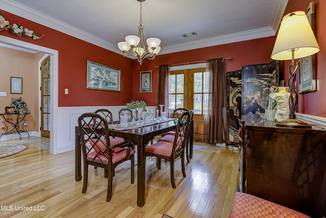 102 Grand Bear Cir, Vicksburg, MS 39183 - dining area with an inviting chandelier, french doors, a wainscoted wall, light wood-type flooring, and ornamental molding