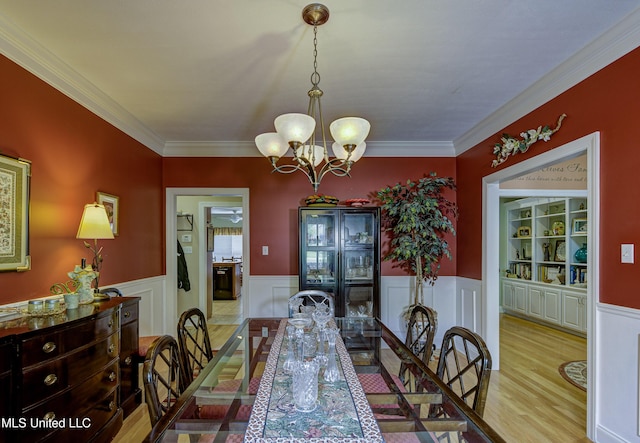102 Grand Bear Cir, Vicksburg, MS 39183 - dining area with wainscoting, an inviting chandelier, crown molding, and light wood-type flooring