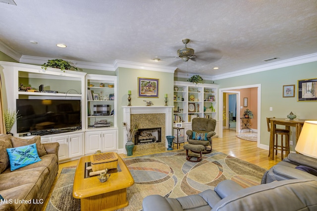 102 Grand Bear Cir, Vicksburg, MS 39183 - living room with visible vents, a fireplace, crown molding, light wood-style flooring, and a ceiling fan