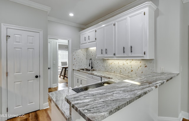 105 Lilac Ct, Madison, MS 39110 - kitchen with white cabinets, wood finished floors, crown molding, decorative backsplash, and light stone countertops