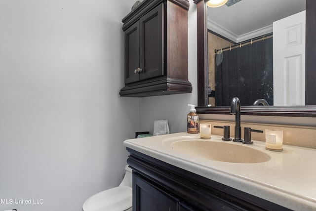 bathroom with crown molding, vanity, and toilet