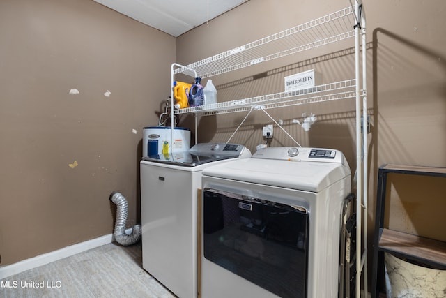 washroom with water heater and washing machine and clothes dryer