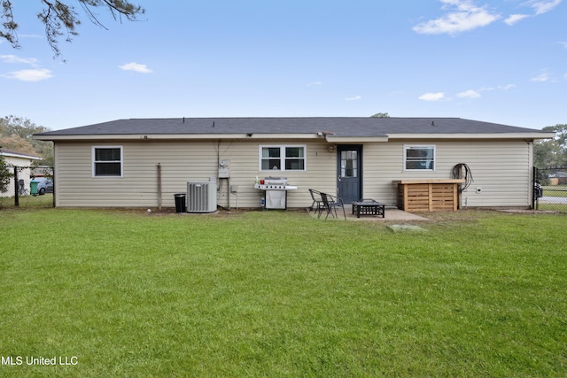 rear view of house featuring a lawn, central AC, a patio area, and an outdoor fire pit