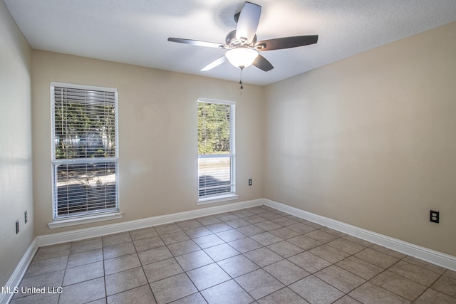 tiled spare room with ceiling fan