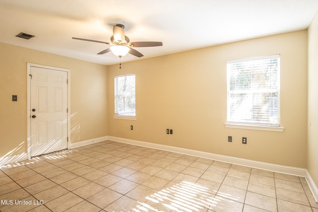 unfurnished room featuring ceiling fan, light tile patterned floors, and a wealth of natural light