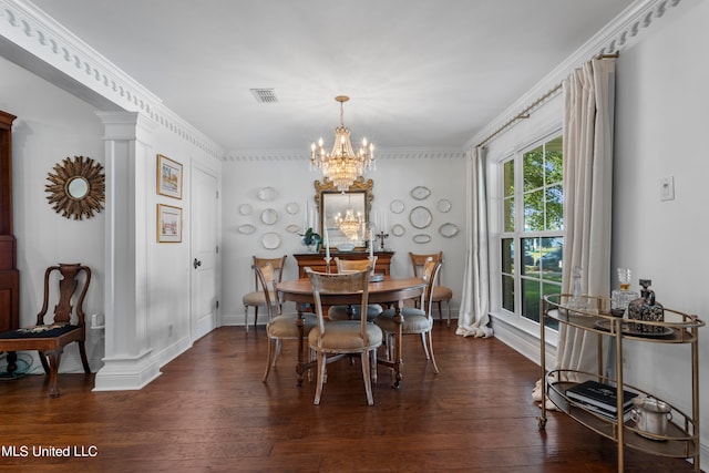 dining area with dark wood-type flooring, ornate columns, crown molding, and an inviting chandelier