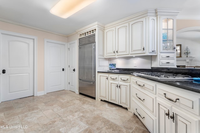 kitchen featuring stainless steel appliances, ornamental molding, and cream cabinetry