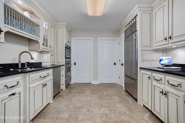 kitchen with appliances with stainless steel finishes, ornamental molding, sink, and cream cabinetry