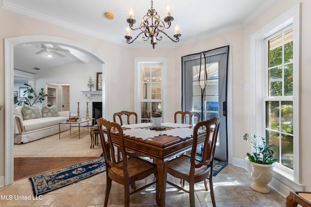 dining space with crown molding, vaulted ceiling, and ceiling fan with notable chandelier