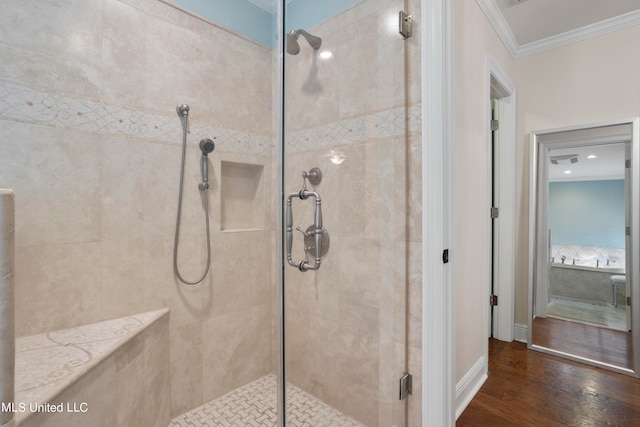 bathroom featuring crown molding, hardwood / wood-style floors, and a shower with shower door