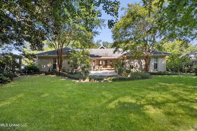 back of property featuring a patio area and a lawn