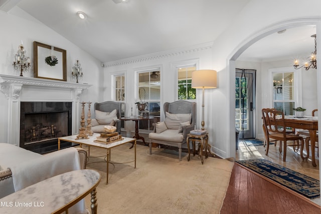 living room featuring a chandelier, vaulted ceiling, and light hardwood / wood-style floors