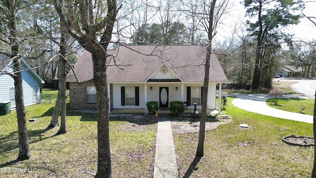 view of front facade with roof with shingles, covered porch, and a front lawn