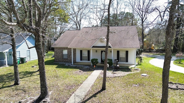 new england style home with a porch, a front lawn, and a shingled roof