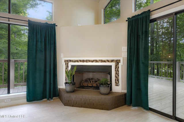 6821 Autumn Oaks Dr, Olive Branch, MS 38654 - living room featuring a brick fireplace, healthy amount of natural light, a high ceiling, and wood finished floors