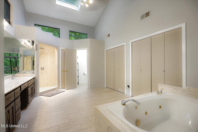 6821 Autumn Oaks Dr, Olive Branch, MS 38654 - full bathroom featuring high vaulted ceiling, vanity, a jetted tub, tiled shower, and wood finished floors
