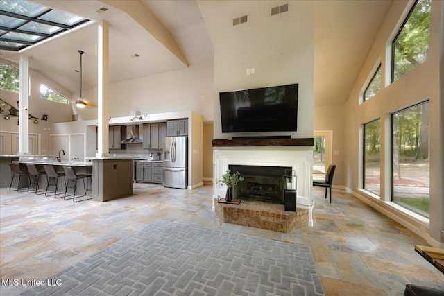 6821 Autumn Oaks Dr, Olive Branch, MS 38654 - living area with high vaulted ceiling, stone tile flooring, a fireplace, and baseboards