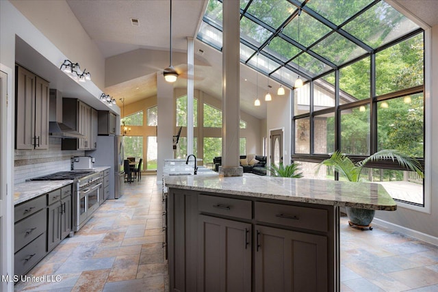 6821 Autumn Oaks Dr, Olive Branch, MS 38654 - kitchen with appliances with stainless steel finishes, wall chimney exhaust hood, gray cabinetry, stone tile flooring, and high vaulted ceiling