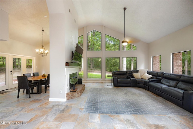 6821 Autumn Oaks Dr, Olive Branch, MS 38654 - living room featuring healthy amount of natural light, high vaulted ceiling, stone tile flooring, a brick fireplace, and a chandelier