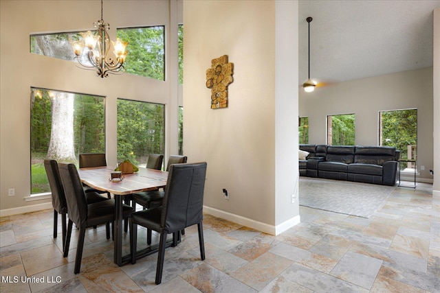 6821 Autumn Oaks Dr, Olive Branch, MS 38654 - dining space with stone tile flooring, baseboards, a towering ceiling, and plenty of natural light