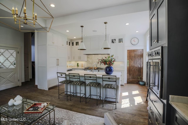 307 Grand Blvd, Greenwood, MS 38930 - kitchen featuring dark wood-style flooring, stainless steel oven, white cabinetry, and tasteful backsplash