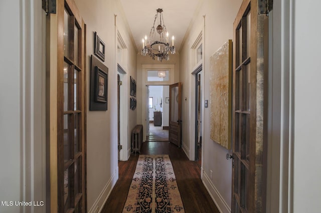 307 Grand Blvd, Greenwood, MS 38930 - hall featuring baseboards, dark wood-type flooring, radiator, and a notable chandelier