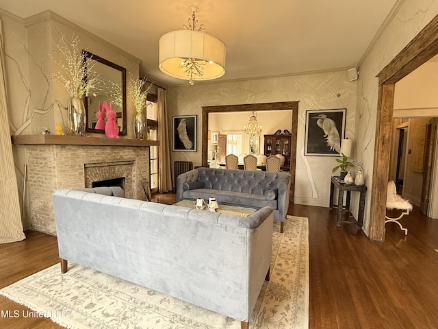 307 Grand Blvd, Greenwood, MS 38930 - living room featuring a notable chandelier, a brick fireplace, baseboards, wallpapered walls, and wood finished floors