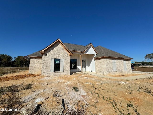 view of front of home with board and batten siding and brick siding