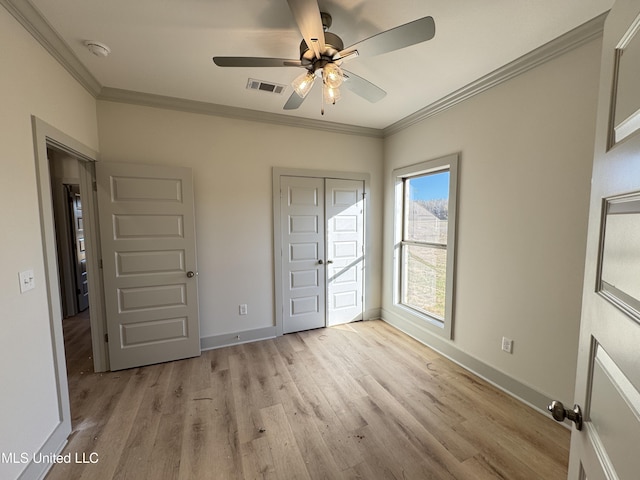 unfurnished bedroom featuring ornamental molding, light wood-type flooring, visible vents, and baseboards