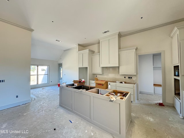 kitchen with a center island, visible vents, vaulted ceiling, and baseboards