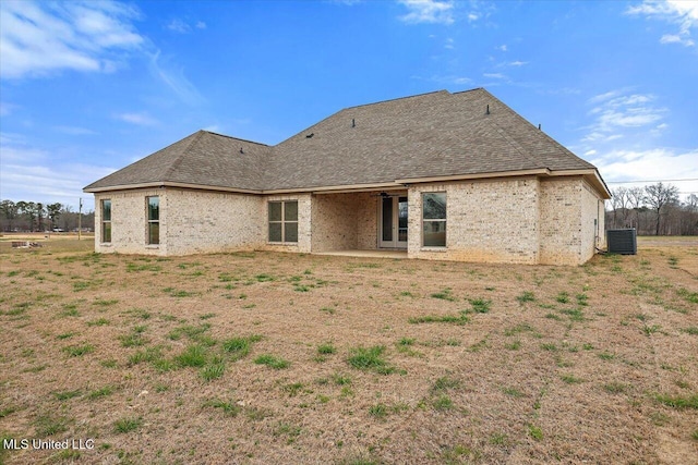 rear view of house with a shingled roof, a patio area, central AC, and brick siding