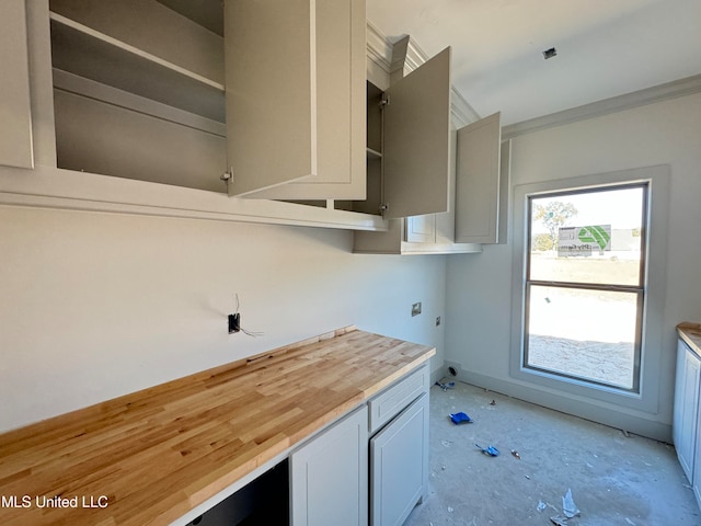 kitchen featuring ornamental molding and wooden counters