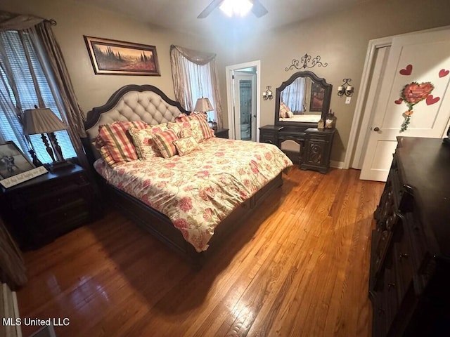 bedroom with baseboards, wood finished floors, and a ceiling fan