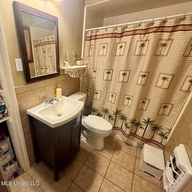 full bathroom with tile walls, toilet, vanity, a shower with curtain, and tile patterned flooring