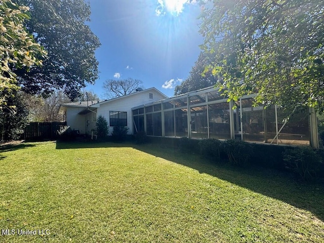 view of yard with a sunroom and fence